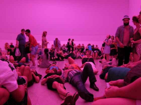 Crowds of people sitting and lying on the floor at Guggenheim looking up at James Turell's Aten Reign exhibition 