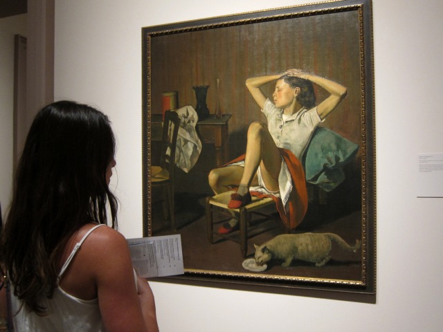 Women looking at the Balthus Girls painting, entitled "Therese dreaming", of a girl sitting with her leg up looking over her shoulder with her eyes closed