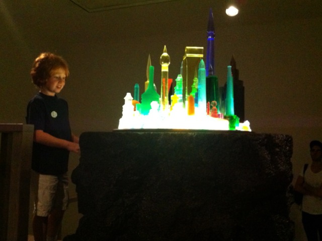 Little boy with his face aglow from Mike Kelley's Future City piece at the MoMa PS1 exhbition