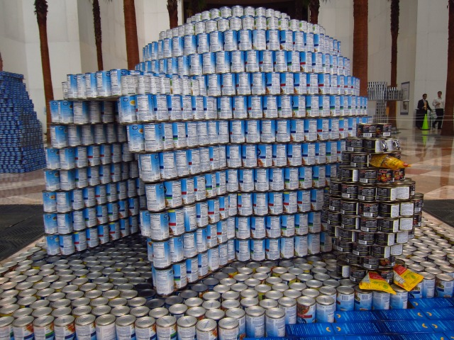 Canstruction entry entitled "Polarized Against Hunger" by GACE Consulting Engineers, which includes a penguin sitting outside of an igloo, all made out of cans