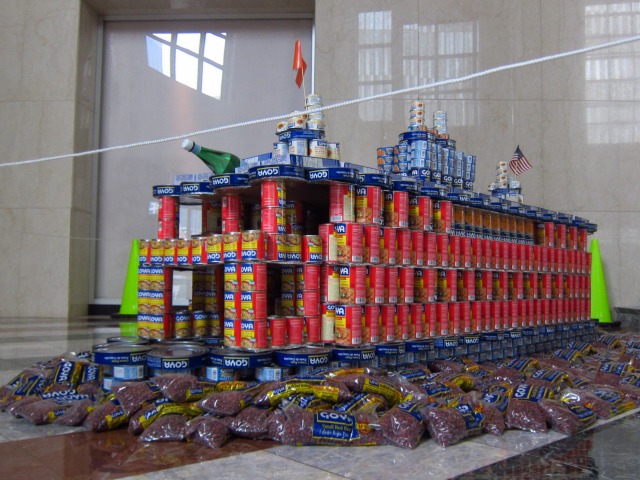 Canstruction entry entitled "Stack'Can Island Ferry" by MTA New York City Transit, which is a rendition of a red ferry cruising the water, all made out of cans