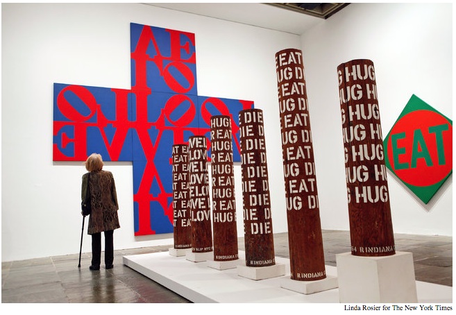 Robert Indiana's Love exhibition at the Whitney showing pillars with the words "hug", "eat", "die", etc. and signage on the walls saying "eat" and "love"