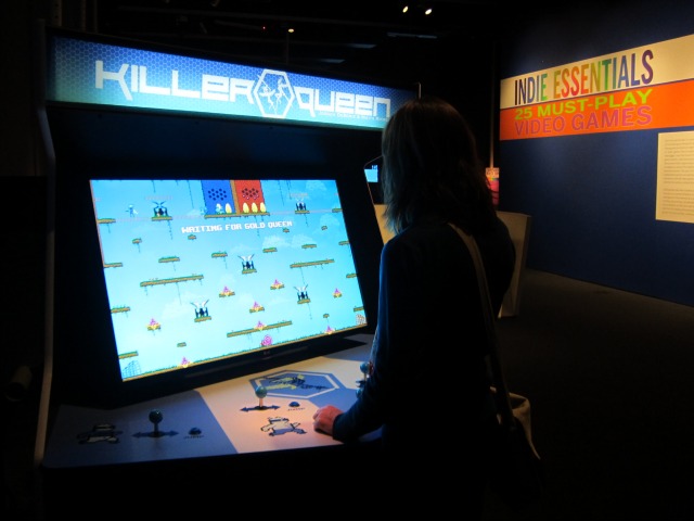 Woman playing a video game called Killer Queen at the Museum of Moving Image's exhibition Indie Essentials