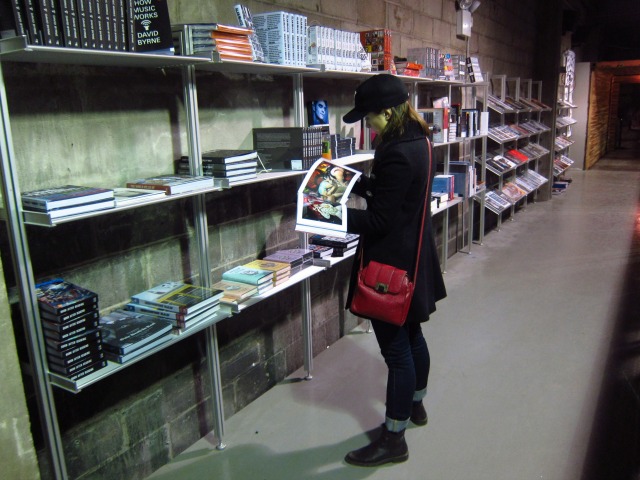 Along with vinyl, cds, and games, Rough Trade NYC also has a large collection of books that this customer is looking through