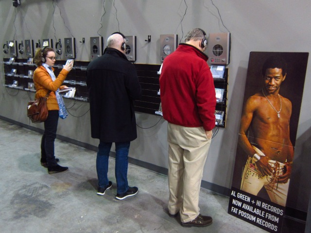 Three customers listening to records and CD's at Rough Trade's listening stations