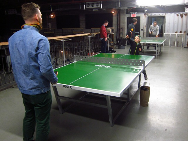 Several Rough Trade customers playing on the ping ping tables within the store in Willamsburg
