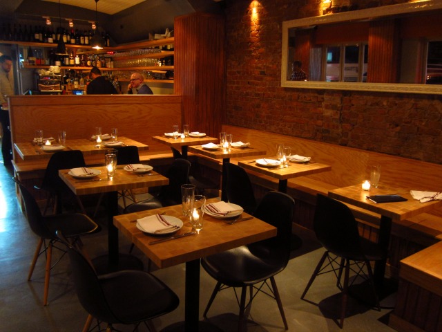 The interior seating at Greek Restaurant Snack OES, with a warm, dim lighting and a bar towards the back 