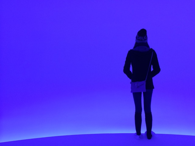 Young women standing in the blue light of Doug Wheeler's Infinity installation at David Zwirner Gallery