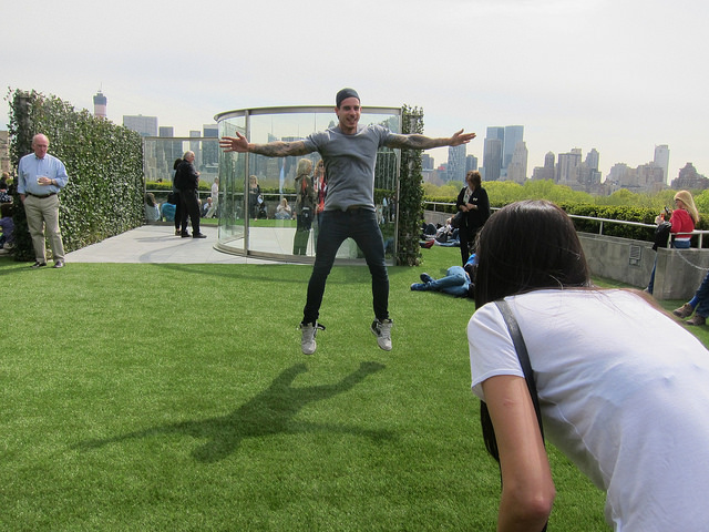 Image of several New York residents up on the Met's Rooftop installation by Dan Graham