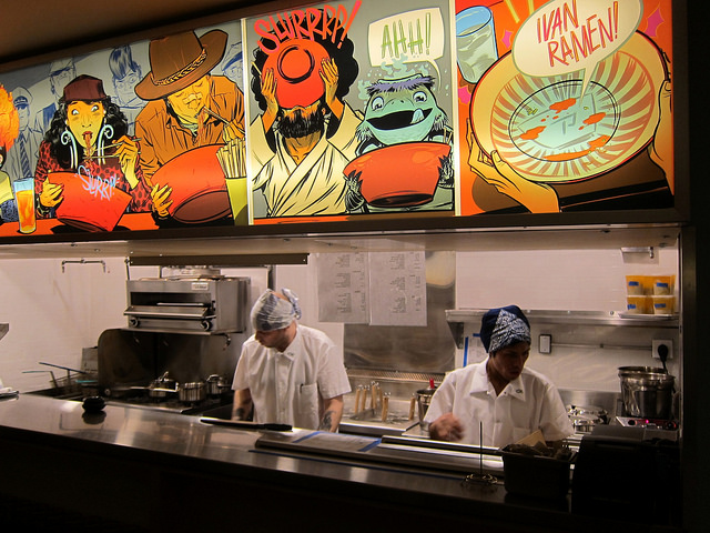 A look inside of the kitchen of Ivan Ramen with two cooks manning the stoves.