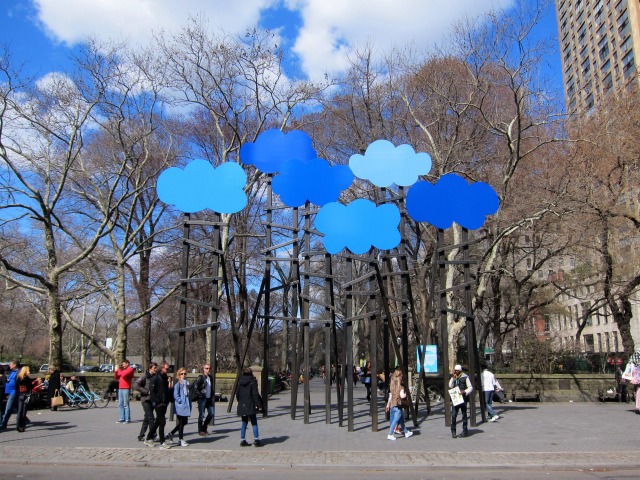 An image of a couple dozen people appreciated the cloud public art by Olaf Breuning located in Central Park