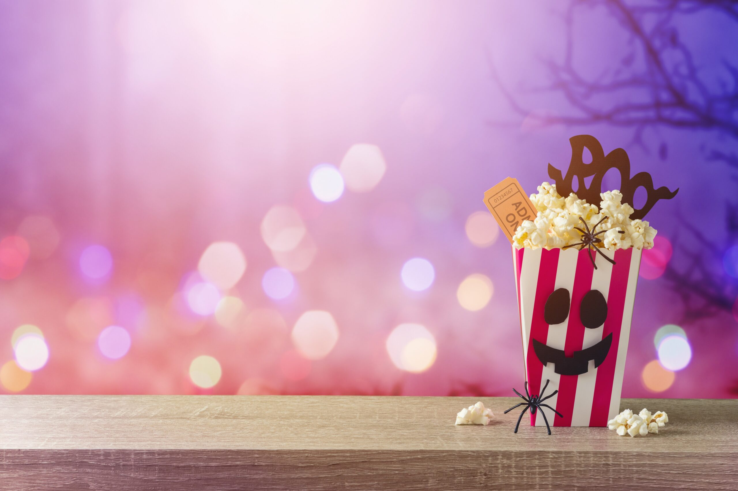 Horror movie night and Halloween party concept with popcorn on wooden table over scary background
