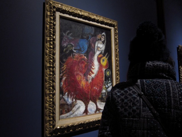 Marc Chagall has on display in a beautiful frame, this painting of him and his wife and a big red bird
