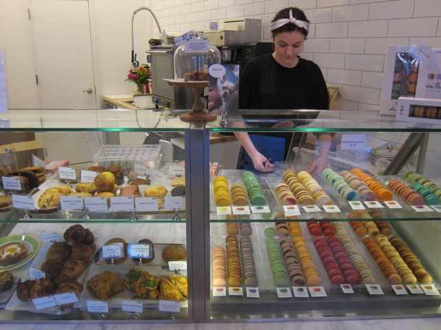 Standing in front of the Macaron Parlour's display case at their new Upper West Side location