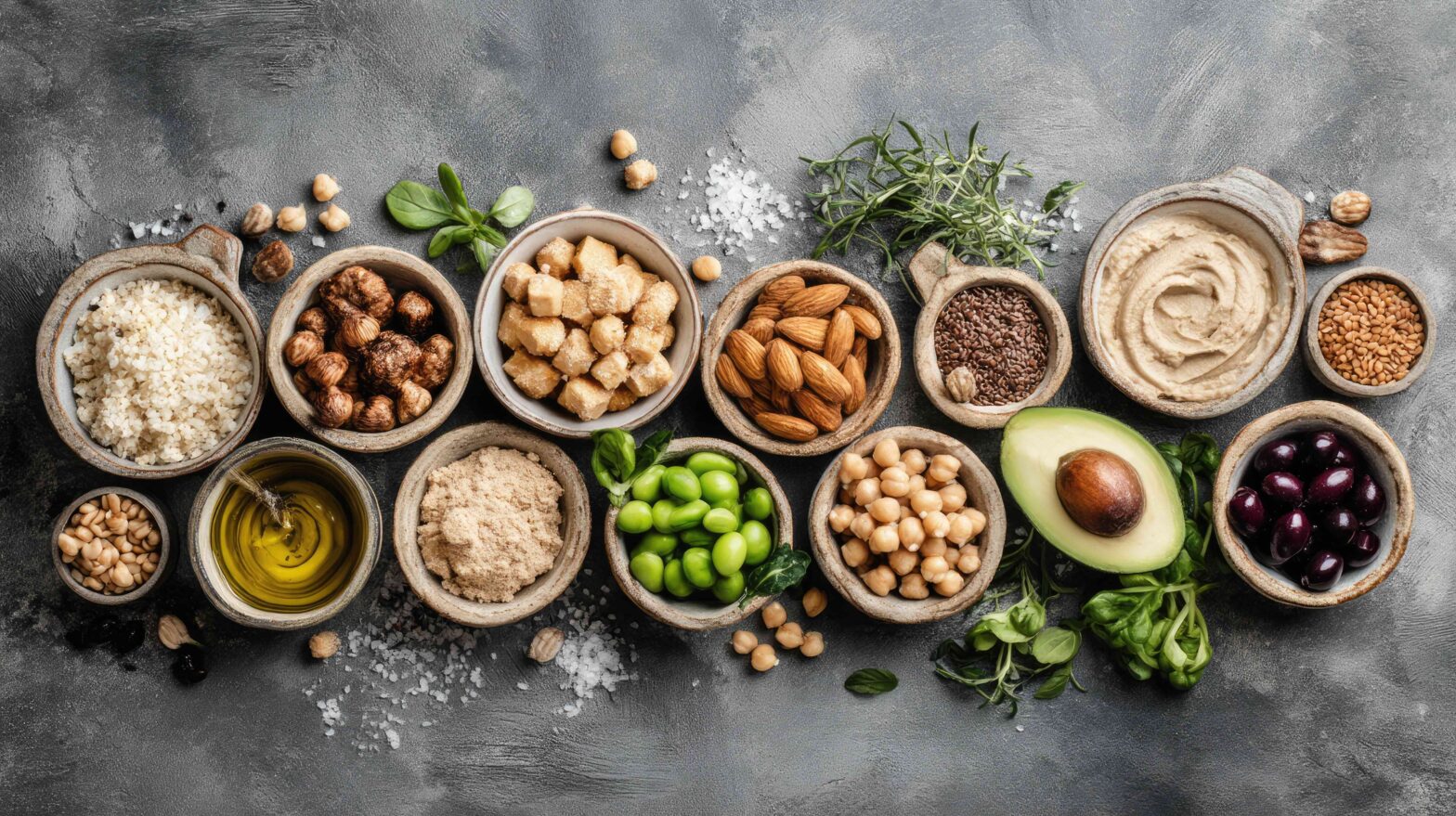 This image showcases a vibrant assortment of fresh ingredients ideal for healthy cooking, featuring nuts, grains, legumes, and oils arranged on a rustic surface.